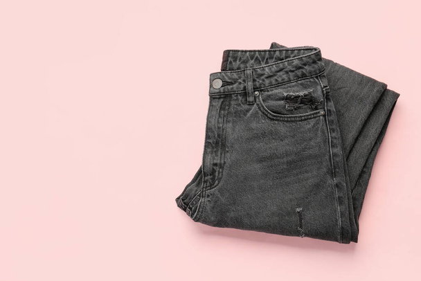 Stylish black denim jeans on pink background - Фото, изображение