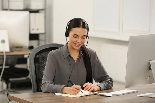 Hotline operator with headset and notebook working in office - Fotografie, Obrázek