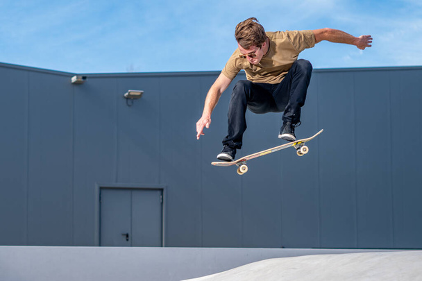 Skateboarder csinál ollie trükk a városi színtéren. - Fotó, kép