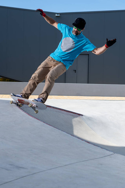 Skateboarder doing frontside five-o grind trick in concrete skatepark. - Фото, зображення