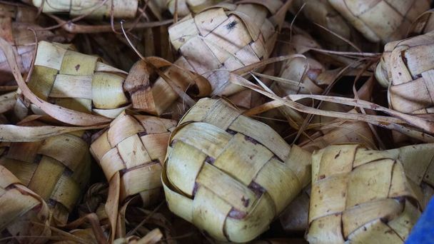 Кетупат - це типова індонезійська страва з рису, загорнута в листя кокосового горіха і варена в гарячій воді і зазвичай з'їдена на ідул фітрі. - Фото, зображення