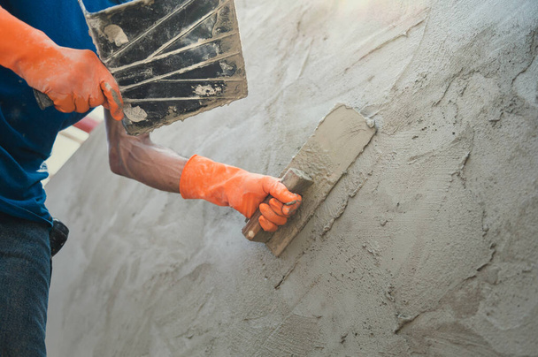 closeup hand of worker plastering cement at wall for building house - Foto, imagen