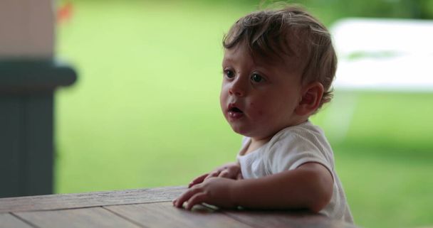 Дитячий малюк тримає на столах меблі
 - Фото, зображення