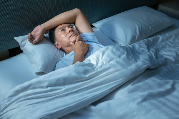 Senior asiatischer Mann, der Probleme mit Schlaflosigkeit hat. Stress, Angst und Depression sind eine häufige Ursache für Schlaflosigkeit. - Foto, Bild