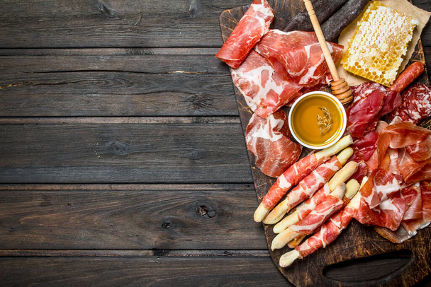 Antipasto background.A variety of meat snacks. On a wooden background. - Fotografie, Obrázek
