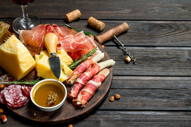 Antipasto background.Board with traditional Italian snacks. On a wooden background. - Fotografie, Obrázek