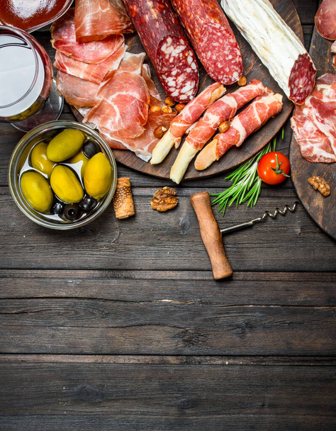 Antipasto background. Assortment of meat snacks on the Board . On a wooden background. - Zdjęcie, obraz