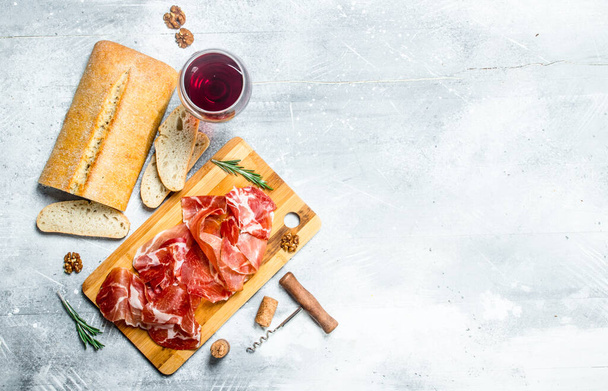 Traditional Spanish ham with ciabatta and red wine. On a rustic background. - Foto, Imagem