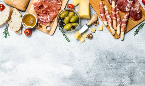 Antipasto background. Variety of Italian snacks. On a rustic background. - 写真・画像