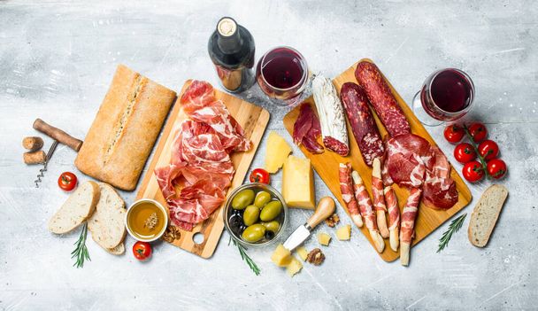 Antipasto background. Different Italian snacks with red wine. On a rustic background. - Foto, immagini