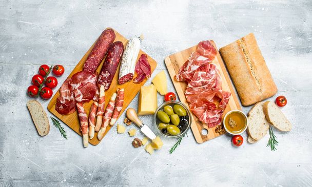 Antipasto background. Variety of Italian snacks. On a rustic background. - Фото, зображення