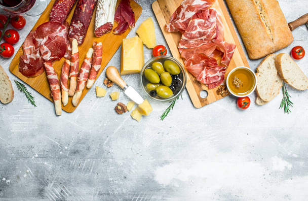 Antipasto background. Variety of Italian snacks. On a rustic background. - Foto, afbeelding