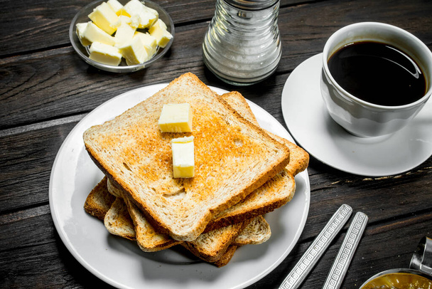 Breakfast. Toasted bread with butter and aromatic coffee. On a Wooden background. - Foto, immagini