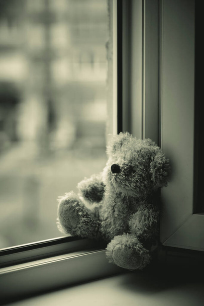 Children toy teddy bear edge open window.Concept of accidents with children - Zdjęcie, obraz