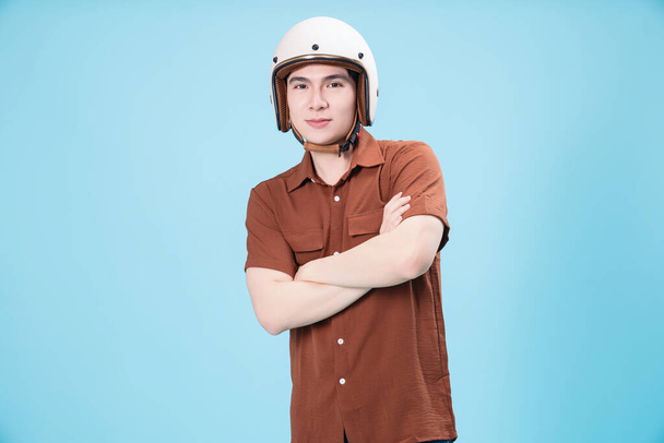Jeune homme asiatique portant un casque sur fond - Photo, image