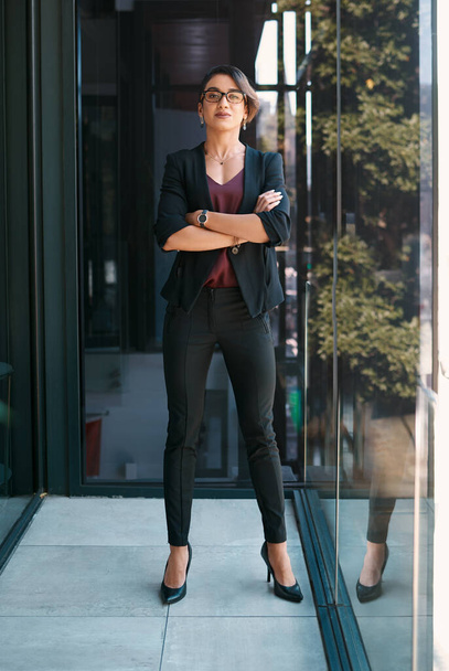 Accomplishing my goals, one at a time. Full length portrait of an attractive young businesswoman standing alone with her arms folded in her office - Foto, afbeelding