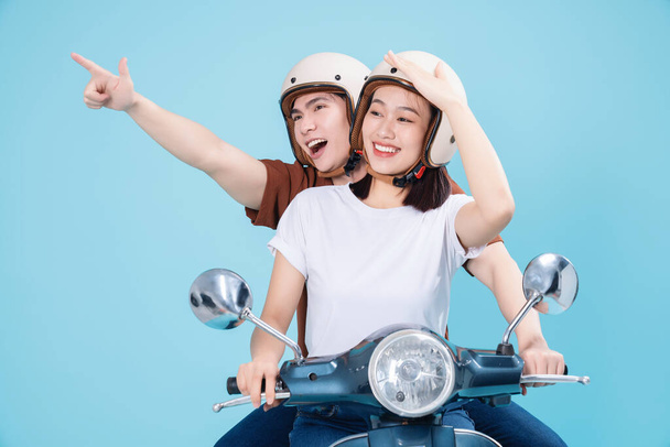 Joven asiática pareja paseo scooter en fondo - Foto, Imagen