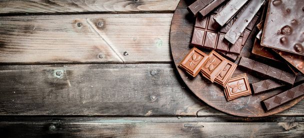Different types of chocolate. On a wooden background. - Foto, imagen