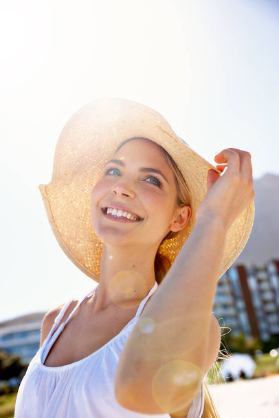 Staying sun safe. a beautiful young woman enjoying a day at the beach - Zdjęcie, obraz