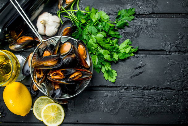 Fresh seafood clams with white wine and parsley. On black rustic background. - 写真・画像