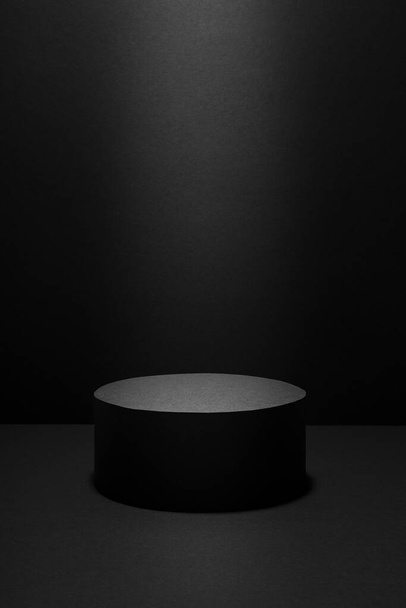 Abstract black scene with one cylinder podium in light beam with light spot template for presentation cosmetic products, goods, advertising, design in gradient, mockup in minimalist style, vertical. - Foto, immagini