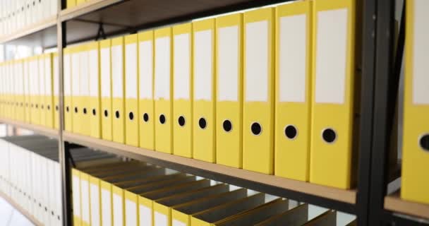 Yellow organized folders structure with materials on shelf of rack in company premise. Concept of saving data in office building archive storage slow motion - Footage, Video