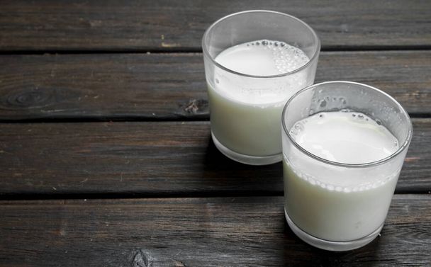 Fresh milk in glasses. On a wooden background. - Фото, зображення