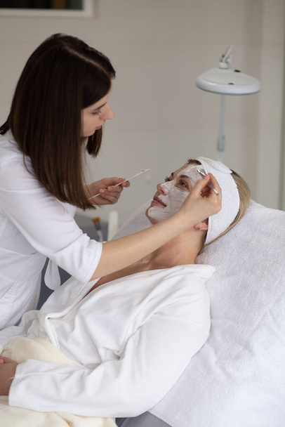 Donna in maschera sul viso in salone di bellezza spa - Foto, immagini