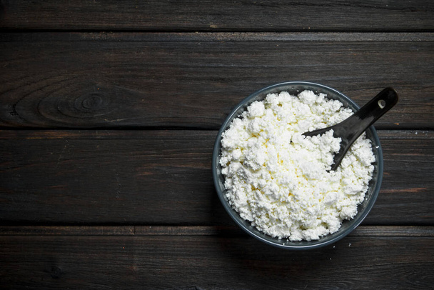 Cottage cheese in bowl. On a wooden background. - Photo, Image
