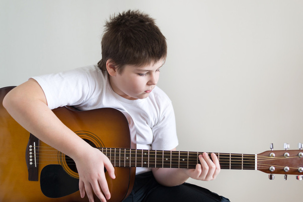 Teenage Boy plays an acoustic guitar - Foto, Imagen
