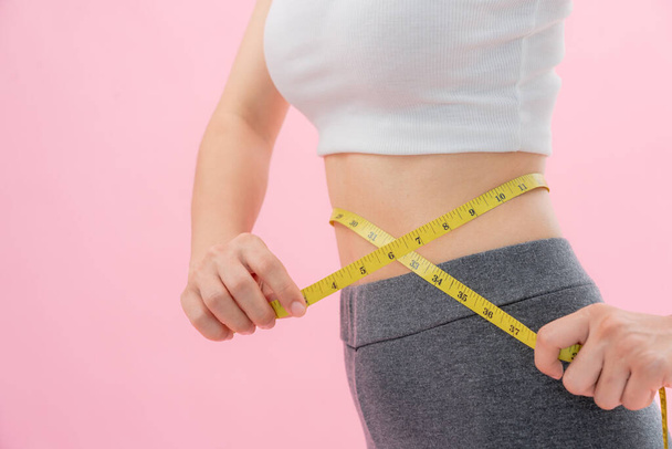 Dieet en dieet. Schoonheid slank vrouwelijk lichaam gebruik meetlint. Vrouw in trainingskleding bereikt gewichtsverlies doel voor een gezond leven, gek op dunne taille, voedingsdeskundige. - Foto, afbeelding