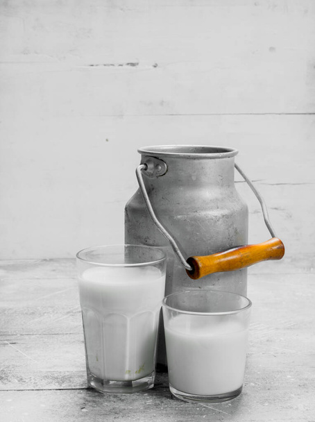 Fresh milk in a can. On a rustic background. - 写真・画像
