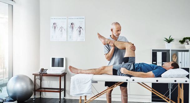 Support, physiotherapist or patient with leg injury, recovery or healthcare for wellness. Male person, client or chiropractor with skills, stretching legs or consultation for physiotherapy or healing. - Foto, Imagem