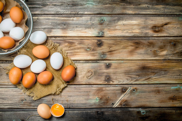 Eggs in a saucepan. On a wooden background. - Φωτογραφία, εικόνα