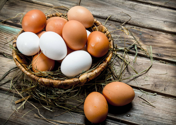 Eggs in a basket. On a wooden background. - 写真・画像