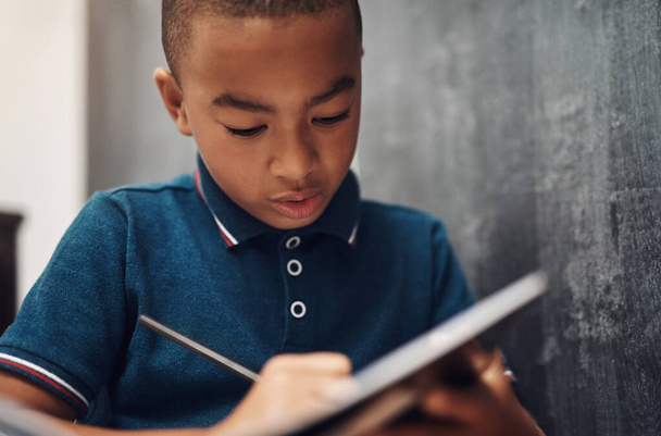 Письмо - это средство коммуникации, связи и творчества. мальчик пишет в книге, сидя дома - Фото, изображение