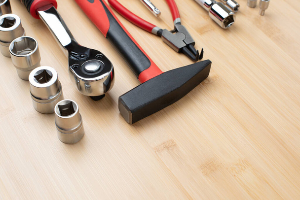 A set of working tools, a hammer, a screwdriver, sockets for repair on a bamboo, wooden background. Top view - Photo, Image