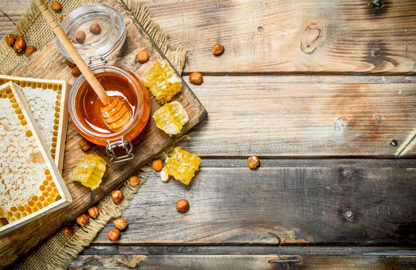 Natural honey with nuts. On a wooden background. - Foto, imagen