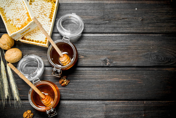 Assortment of different types of honey. On a wooden background. - Zdjęcie, obraz