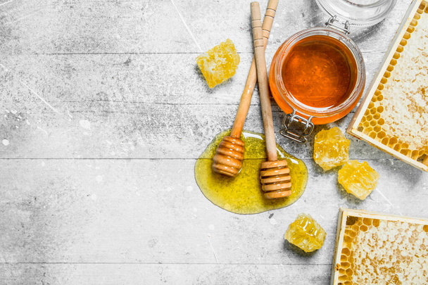 Natural honey in honeycombs with wooden spoons. On a rustic background. - Fotoğraf, Görsel