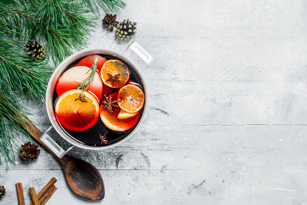 Hot mulled wine in a saucepan. On a rustic background. - Foto, afbeelding