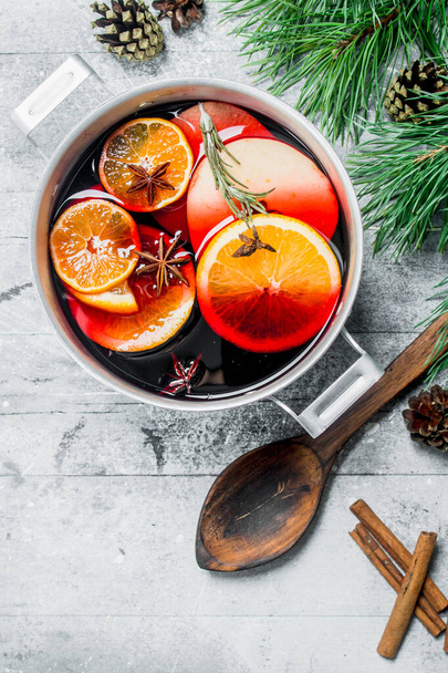Hot mulled wine in a saucepan. On a rustic background. - Foto, afbeelding