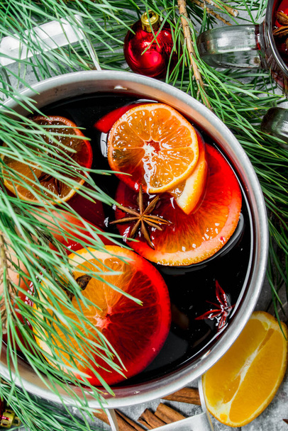 Mulled wine in a saucepan with spices and seasonings. On a wooden background. - Foto, Bild