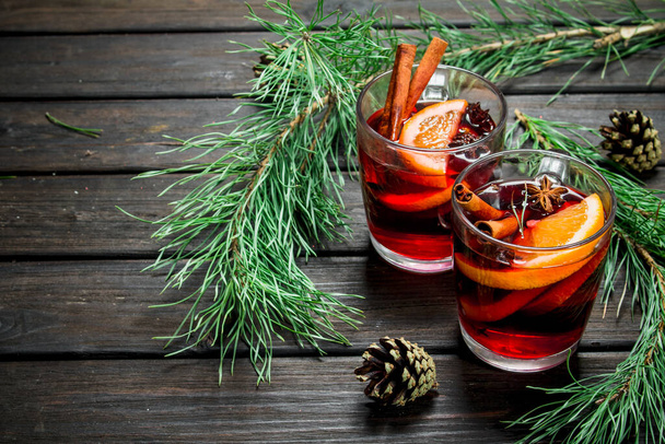 Mulled wine with spices. On a wooden background. - Photo, image