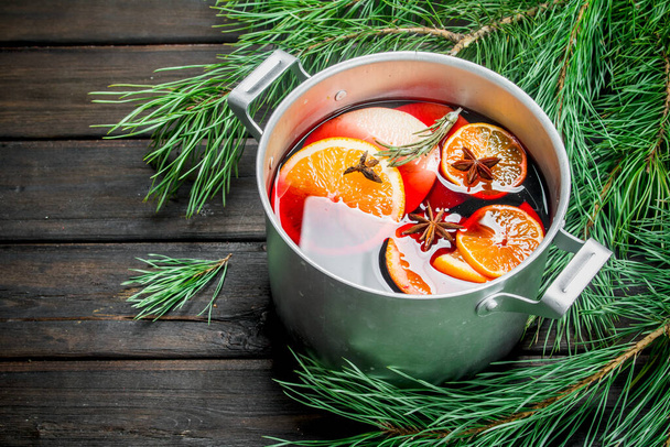 Mulled wine with fir branches. On a wooden background. - Фото, зображення