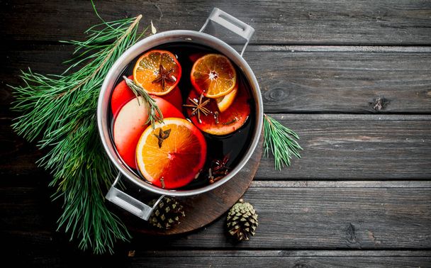Mulled wine with fir branches. On a wooden background. - 写真・画像