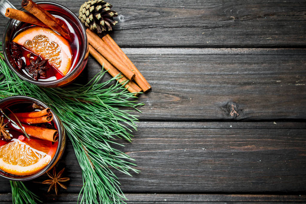 Mulled wine with spices. On a wooden background. - Zdjęcie, obraz