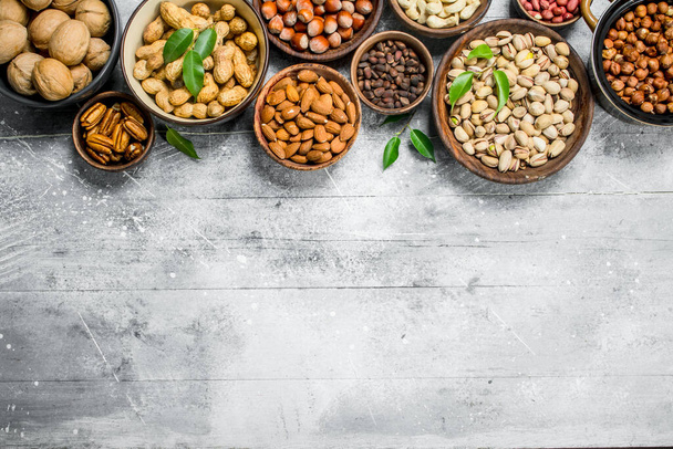 Assortment of different nuts in bowls. On a rustic background. - Photo, Image