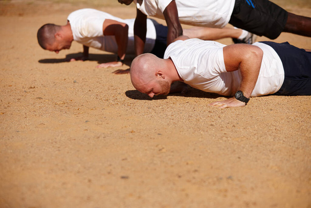 Bootcamp takes determination and an iron will. a group of men doing push-ups at a military bootcamp - Foto, Imagem
