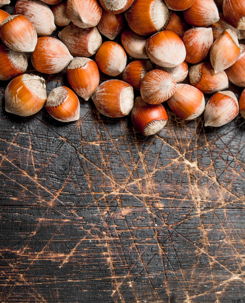 Hazelnuts in the shell. On a wooden background. - Foto, immagini